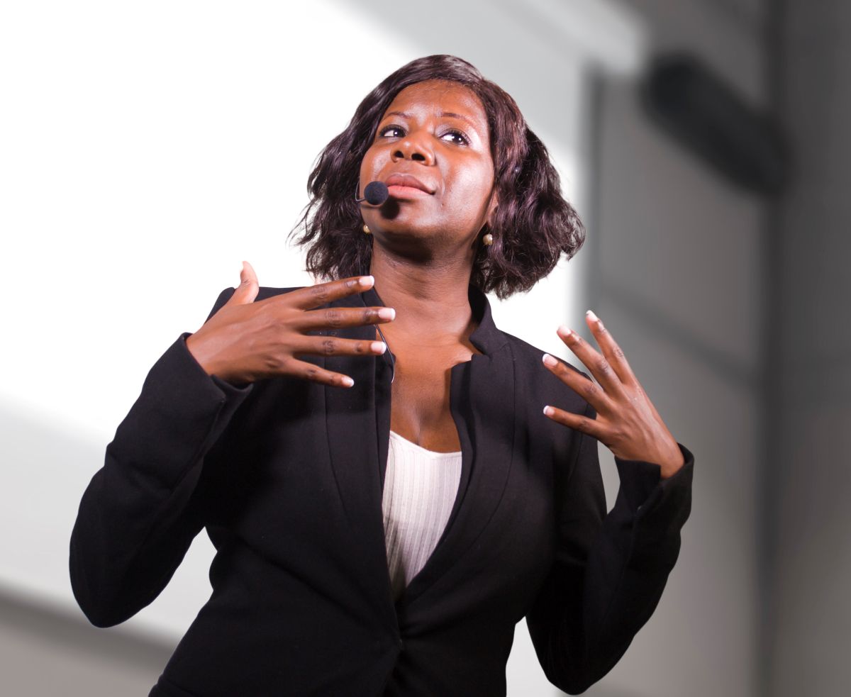 Closeup photo of a woman with a headset microphone speaking at a conference
